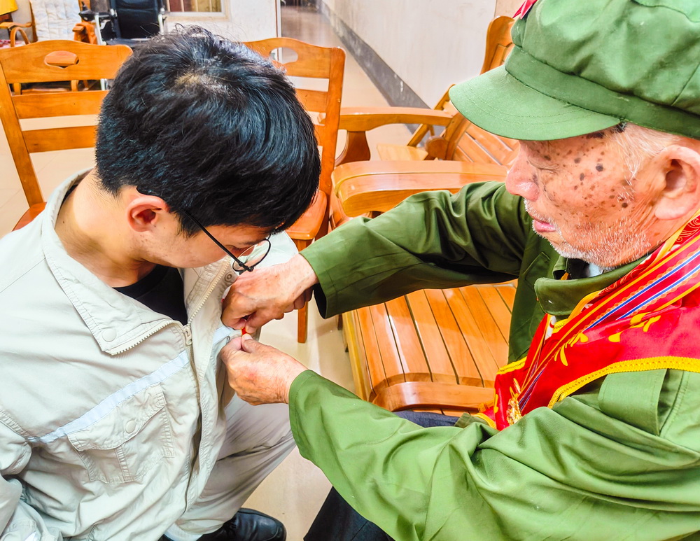 2、韋仕隆給新入黨的青年黨員佩戴黨章--李陽攝.jpg